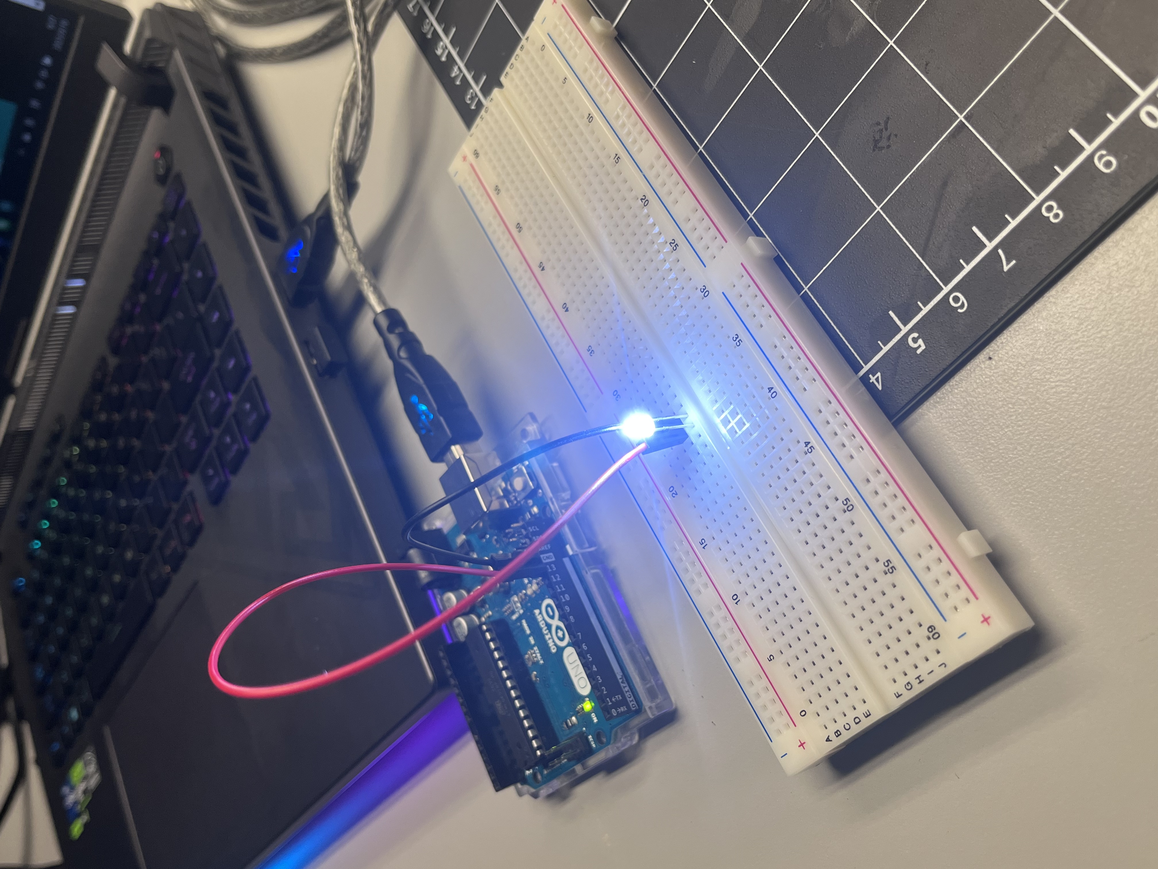 Photo 1:
      The initial setup of the breadboard and Arduino UNO. The LED and resistor were inserted into the breadboard, and a red jumper wire connects the positive rail to digital pin. Once the USB was plugged into the computer, the board’s power LED turned on, confirming the system was powered correctly.
       <a href='https://www.youtube.com/embed/tgbNymZ7vqY' target='_blank'><p>Project Video Link</p></a>